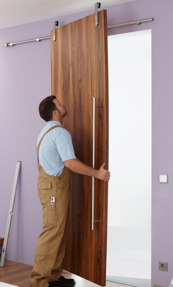 Einhängen einer losen Holzschiebetür in Edelstahlschienen durch einen #Branche1#